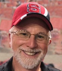 Dave Goff smiling in an NC State hat.